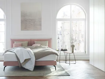 Rosa Design Polsterbett in einem hellen Schlafzimmer.