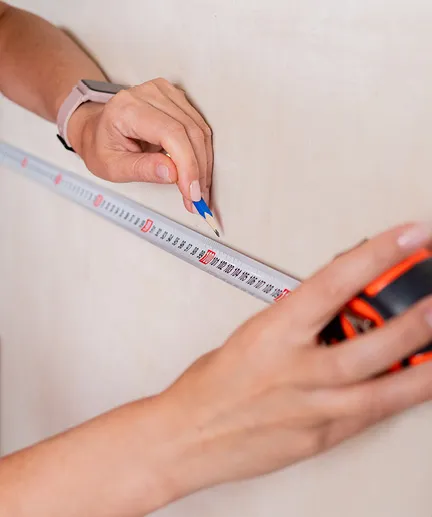 Maßband dient als Hilfsmittel zur Zentimeter genauen Markierung an einer Wand.