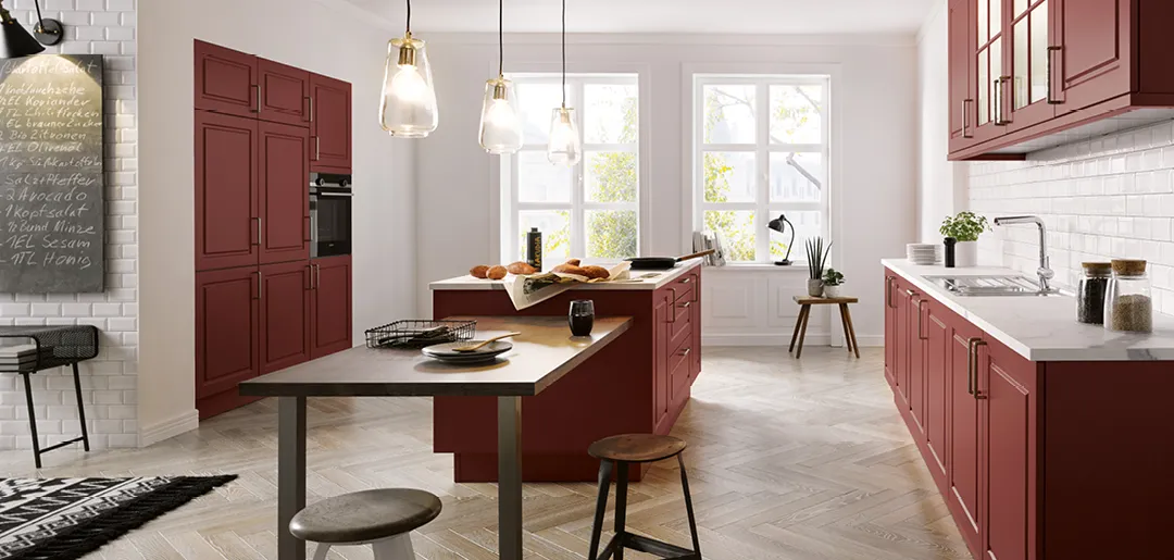 Moderne Landhausküche von Global Küchen mit roten Fronten und Küchentresen in einem hellen Raum mit Holzfußboden