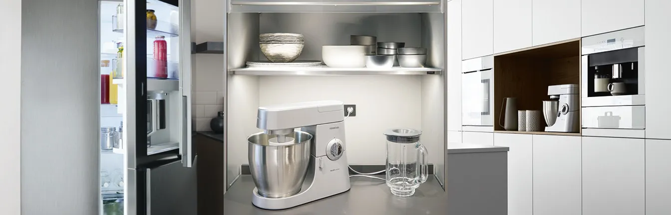 Küchenwand mit Ofen Kaffeemaschine und Rührgerät, sowie einem 'Smart' Kühlschrank mit Glasdurchsicht.