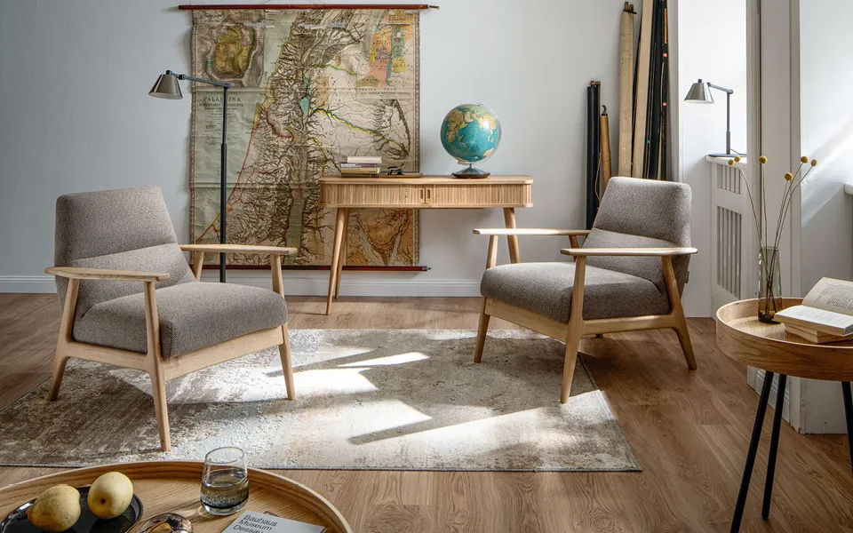 Zeitlos eingerichteter Raum mit naturholz Möbeln und Laminatboden.
    