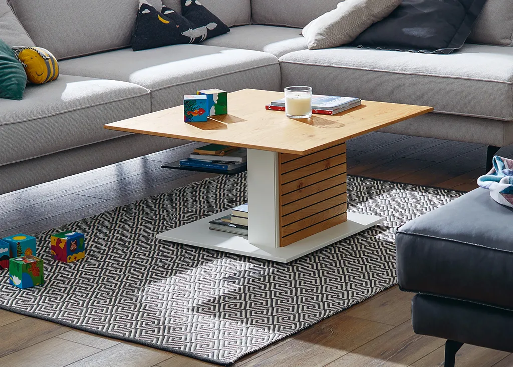 Stylischer Couchttisch mit weißen Akzenten und Holztischplatte vor gemütlichem grauen Sofa im Wohnzimmer