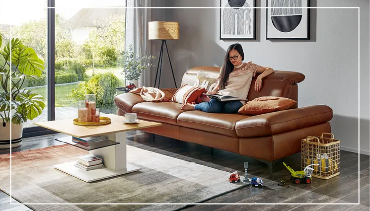 Frau auf ergonomischem Sofa aus Leder mit verstellbaren Armlehnen und Rückenlehnen