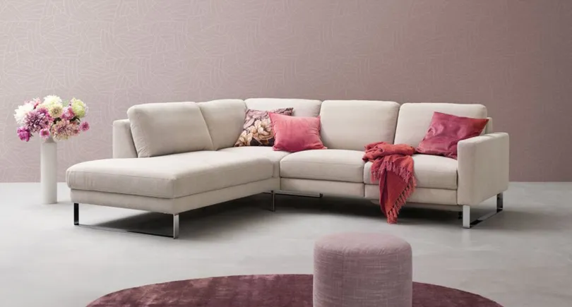 Helles Sofa mit Drehsitzen in einer Umgebung in Aubergine und Pink