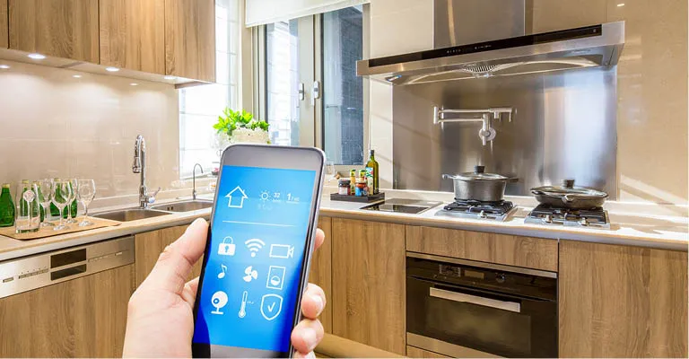 Handy zeigt Funktionen einer smart Kitchen. Im Hintergrund eine moderne Küche.