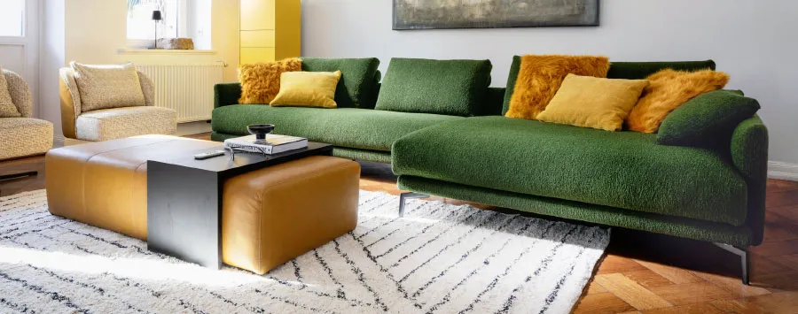 Gemütliches Wohnzimmer mit waldgrüner Couch und Couchtisch