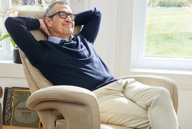 Mann im hellen Global sitz.konzept 4.0 Sessel, entspannt vor dem hellen Wohnzimmerfenster