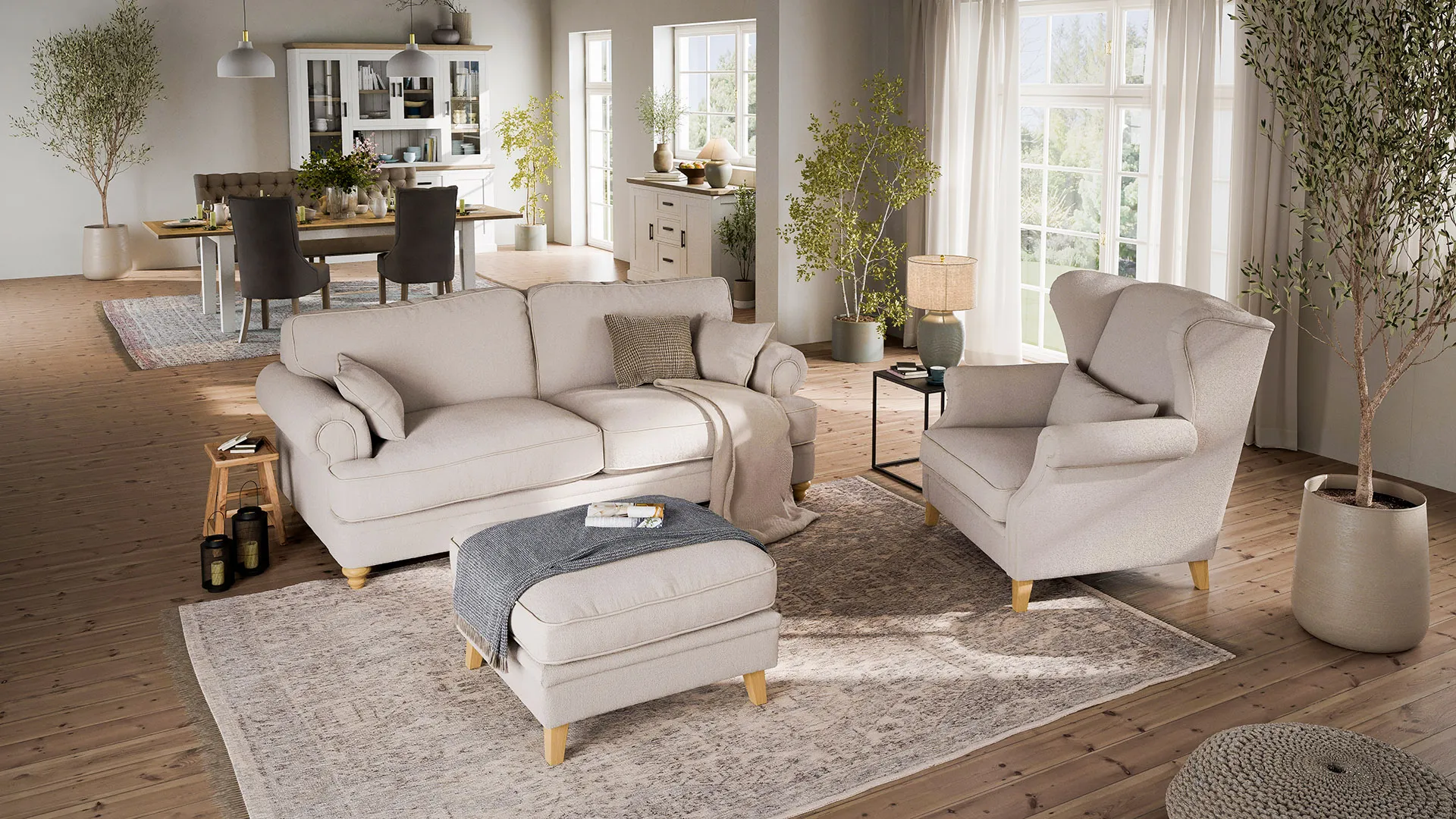 Gemütliches helles Wohnzimmer mit beigem Sofa, beigem Hocker und Sessel im Landhausstil