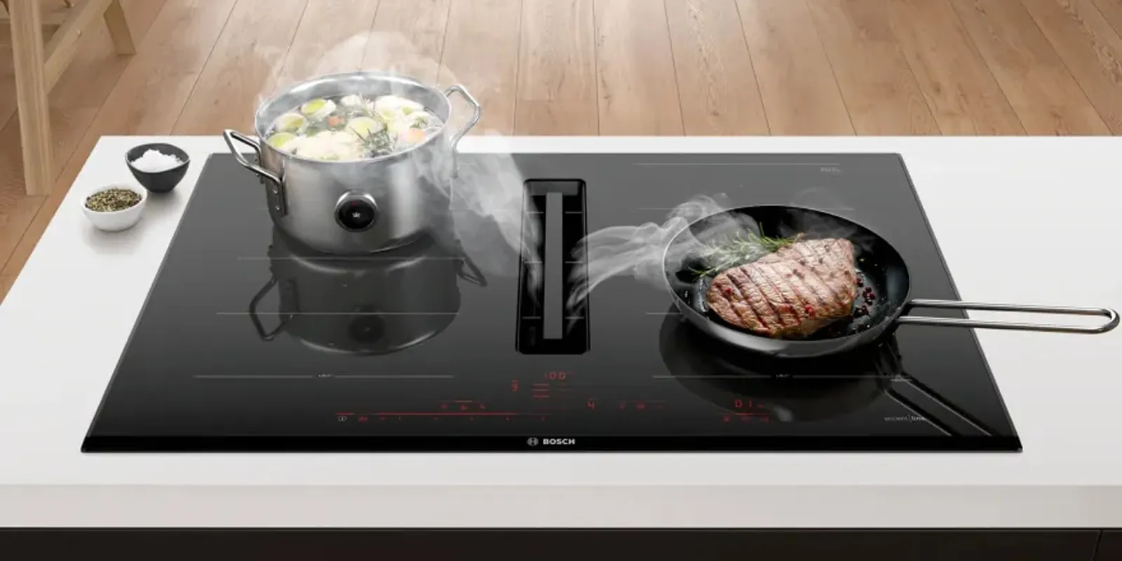Kochfeld von Bosch, das die Funktion zeigt, eine eingebaute Dunstabzugshaube zu haben, die beim Kochen den entstehenden Dampf direkt abzieht. 