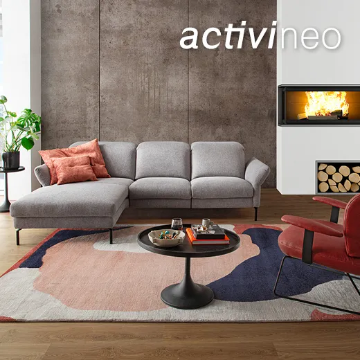 Graues Stoffsofa in offenem Wohnzimmer in Loftwohnung