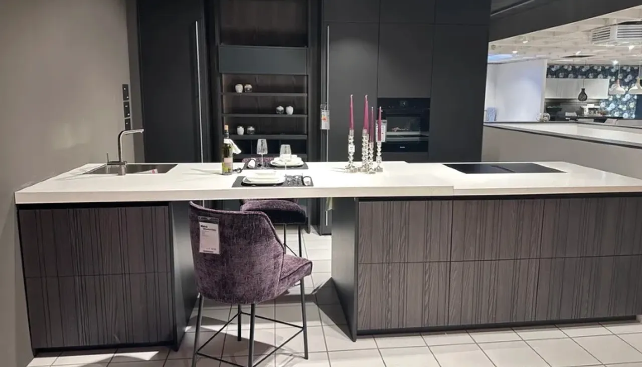 Stilvolle Leicht Küche in dunklem Design mit großer Kochinsel, weißer Arbeitsplatte und integriertem Induktionskochfeld. Moderne Einbauküche mit Barhocker, Esstheke und hochwertiger Ausstattung für luxuriöses Wohnen.