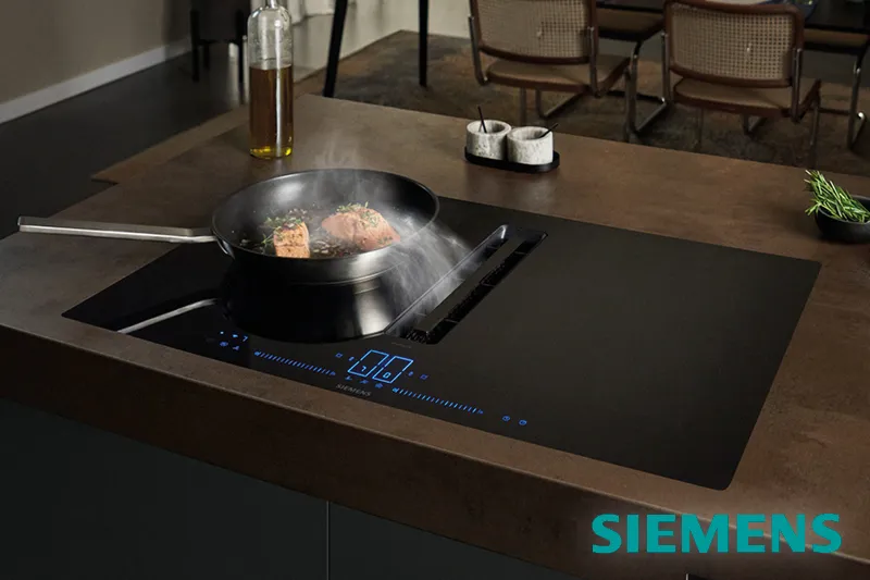 Siemens Herdplatte mit Muldenluefter und Pfanne in hochwertiger Designkueche und Siemens-Logo