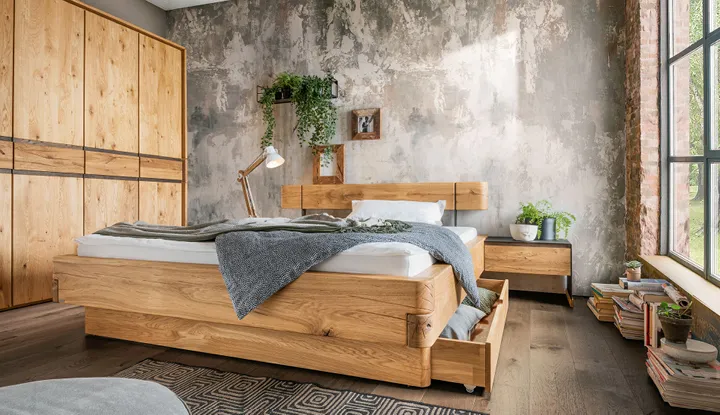 NATURA HOME Bett aus Massivholz auf Holzboden vor Kleiderschrank aus Naturholz im Schlafzimmer