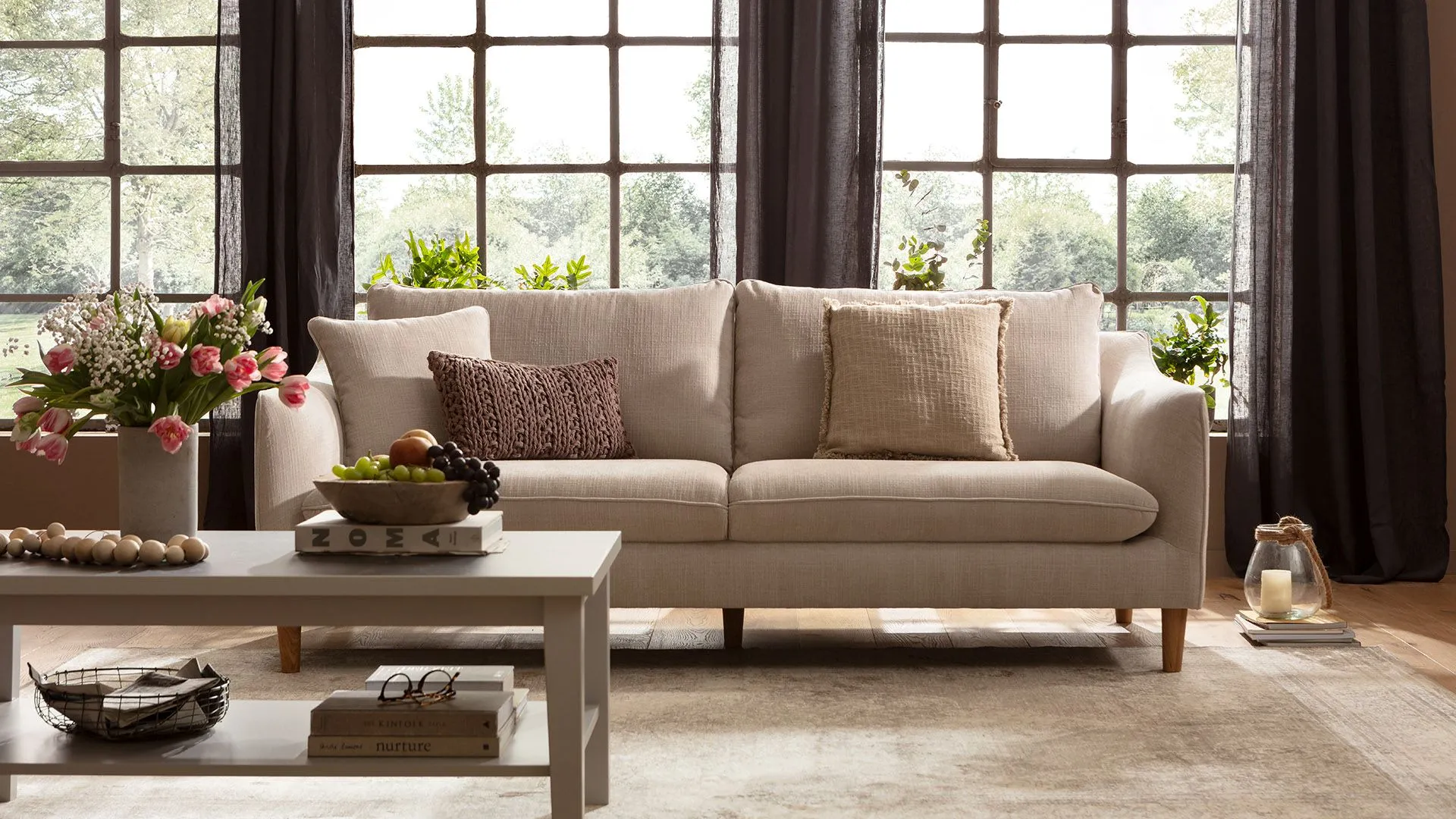 Beiges gemütliches Sofa mit großen Rückenkissen und Holzfüßen
