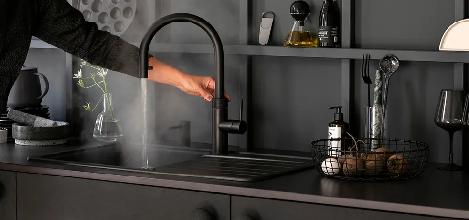 Stylisch schwarze Küchenschränke mit Spüle und Wasserhahn.