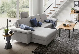 Hellgraues Stoffsofa in hellem Wohnzimmer