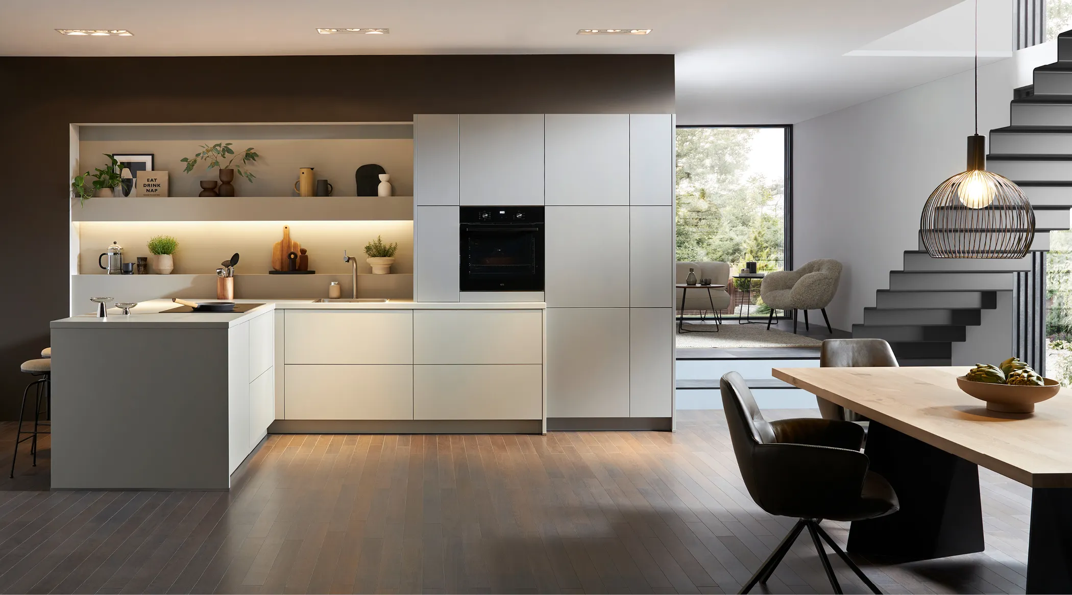 Moderne Grifflose Küche mit weißen glatten Oberflächen in großem Raum.