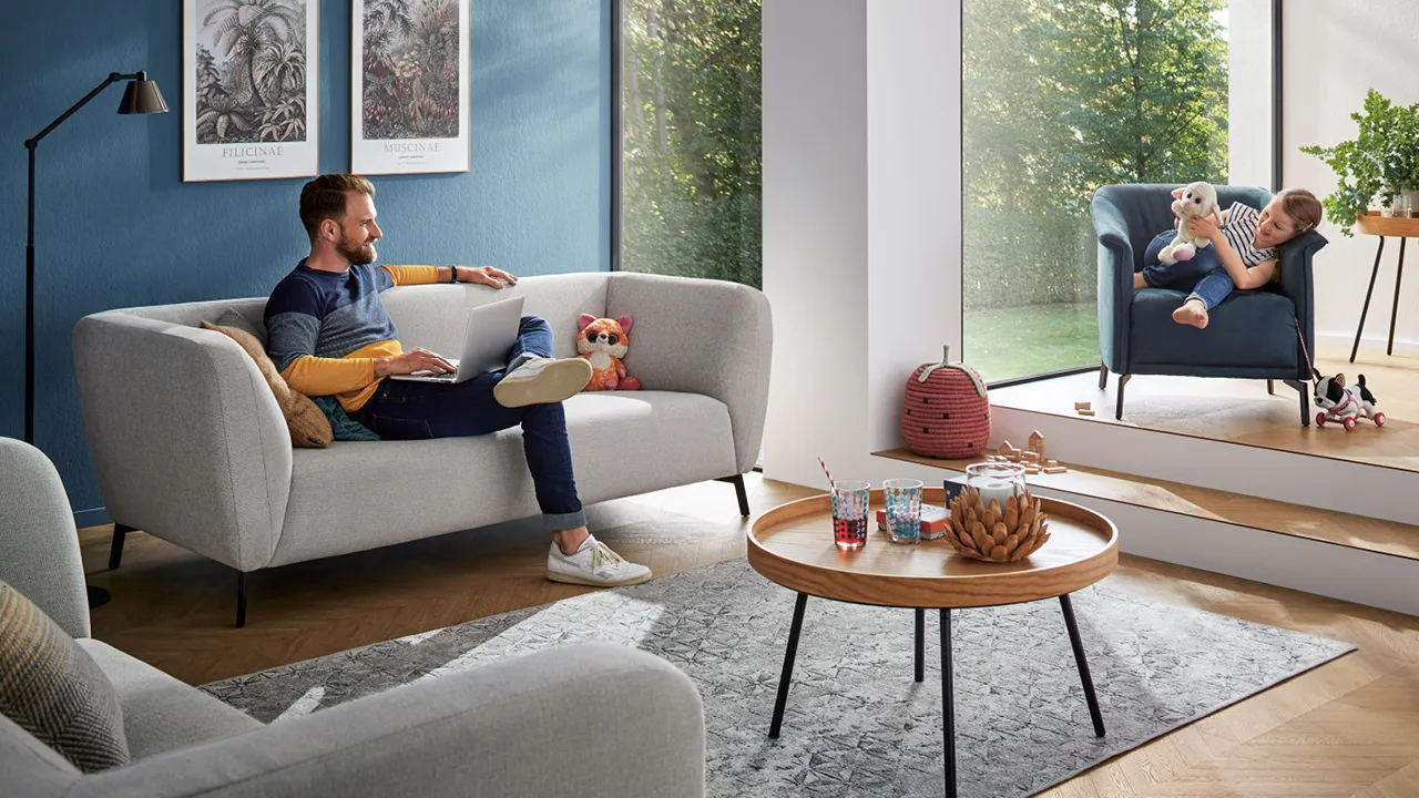 Vater mit Kind sitzend im Wohnzimmer