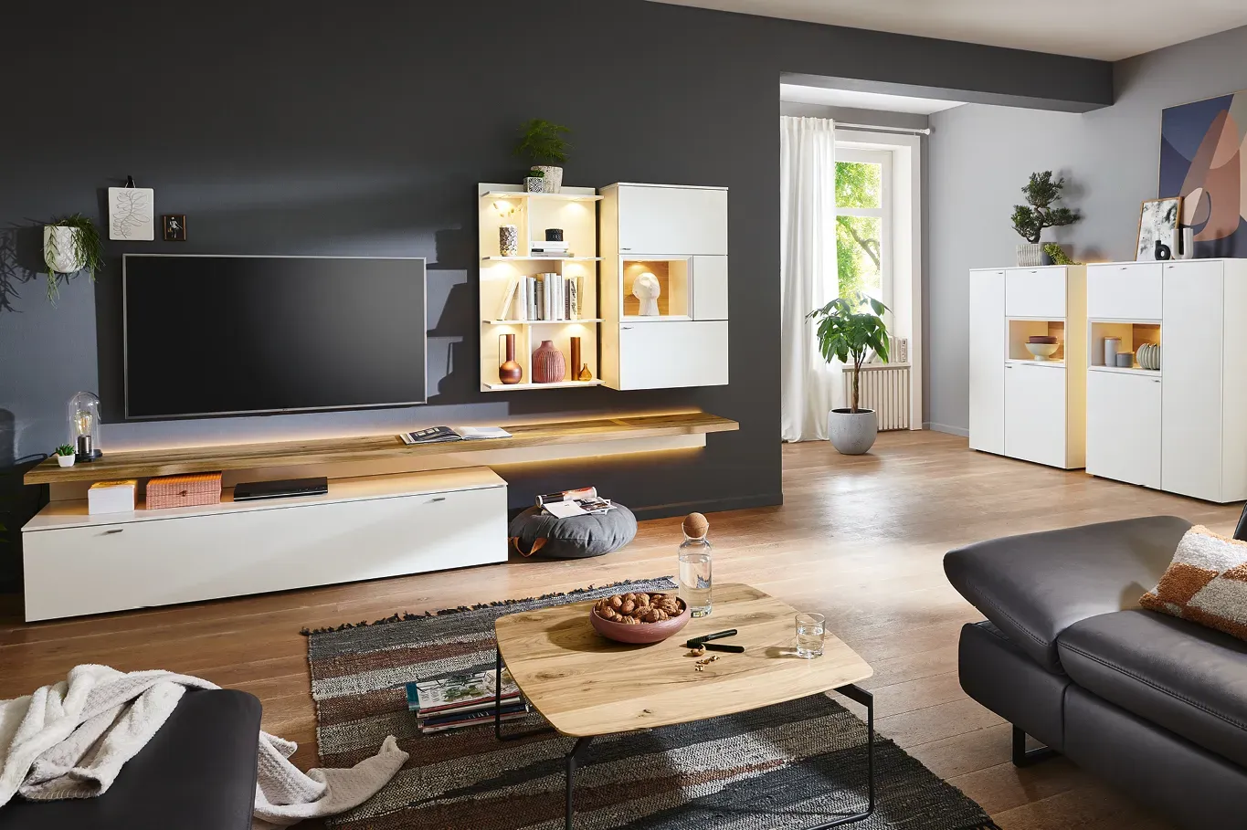 Weisse Wohnwand mit Holzakzenten und passendem Highboard in modernem Wohnzimmer