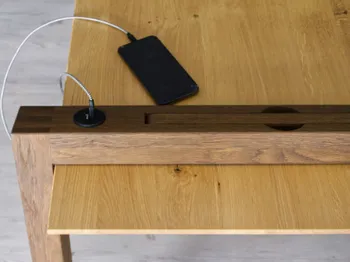 Smartphone wird am Schreibtisch geladen