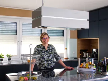 Frau in moderner blauer Küche