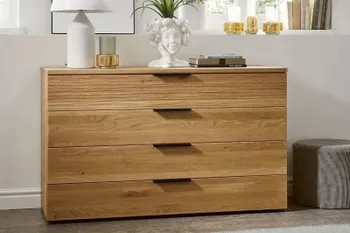 Kommode aus Massivholz mit vier Schubladen in einem hellen Raum.
