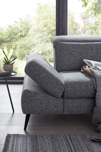 Klappbare Armlehne eines grauen Sofas.