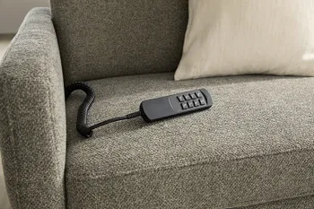 Graues Sofa mit motorischem Sitzvorzug per Fernbedienung.