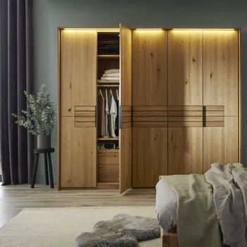 Massivholz Kleiderschrank mit Beleuchtung oben am Schrank und schwarzen Griffen mit geöffneter Tür.