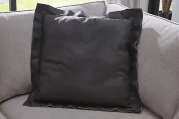 Schwarzes Dekokissen, das es als Zubehör zu einem Sofa gibt.