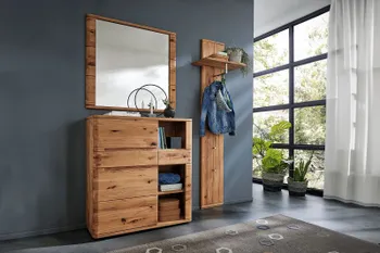 Alternativer Text Garderobe aus Massivholz bestehend aus einem Spiegel, darunter Highboard, Garderobenhaken mit Hutablage an einer blauen Wand.