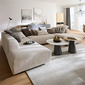 Elegantes Wohnzimmer mit großer Wohnlandschaft in beigem Stoff und zwei runden Couchtischen in Marmoroptik.