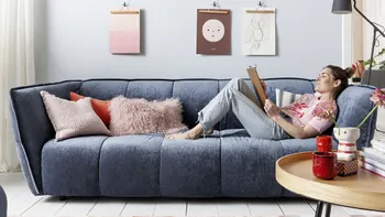 Frau relaxt auf bluer Couch