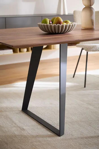 Design Esstisch mit Nussbaumholz Tischplatte und schwarzem Gestell.