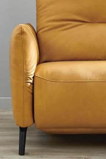 Linker Teil eines gelben Ledersofas mit schwarzem Fußgestell.