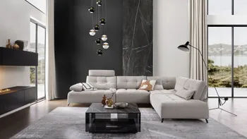 Großes beiges Ecksofa mit Steppung mit schwarzen Metallfüßen, dekoriert mit mehreren Kissen in beige, weiß, grau, orange in einem modernen Wohnzimmer mit schwarzer Wand.