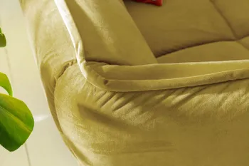 Abgerundete Ecke eines gelben Sofas mit moderner Steppung.