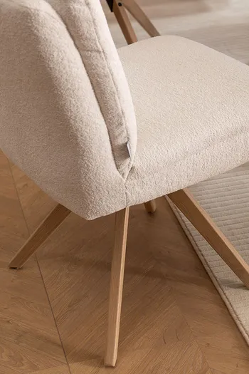Holzgestell eines Polsterstuhls in beigem Stoff fürs Esszimmer.