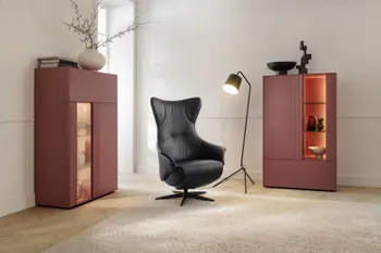 Schwarzer Leder Relaxsessel zwischen zwei roten Highboards.