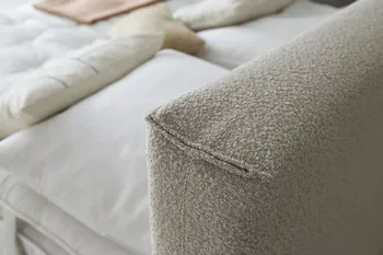 Nahansicht der Kante eines Kopfteils eines beigen Boxspringbettes.
