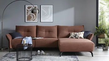 Rotes Ecksofa mit bequem gepolsterten Rückenkissen mit Quernaht und schwarzen Füßen.