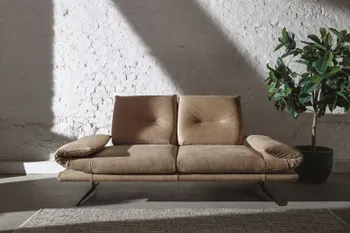 Beiges Ledersofa mit eingedrehten Armlehnen und schwarzen Füßen.