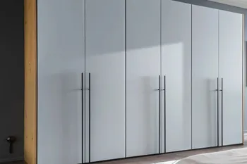 Großer Kleiderschrank mit grauen Drehtüren und langen Metallgriffen in silber.