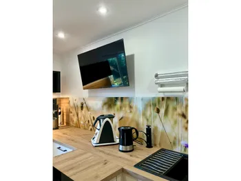 Küchengeräte in einer t-förmigen Küche mit Holzoptik