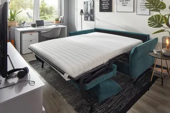 Smaragdgrünes Sofa umgebaut zum Bett.