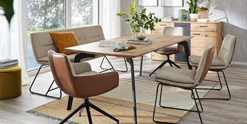Moderne Sitzbank und Stühle, die außen mit Leder in Cognac und innen mit beigem Stoff bezogen sind um einen Massivholz Esstisch.