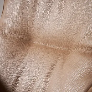 Rückenlehne eines braunen Designer Relaxsessels, der mit Leder bezogen ist in Nahansicht.