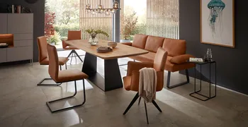 Moderne Esszimmerstühle und Sitzbank mit Leder in Cognac bezogen und schwarzem Metallgestell um einen modernen Esstisch aus Massivholz.