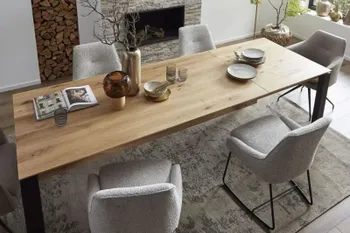 Graue Esszimmerstühle mit schwarzem Metallgestell an einem großen Holzesstisch,