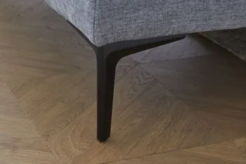 Schwarzer Fuß eines grauen Sofas.